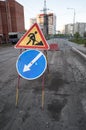 Road repairs, road signs and a bunch of crushed stone on the road Royalty Free Stock Photo