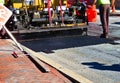 Road repaving: paver laying down fresh asphalt. Royalty Free Stock Photo