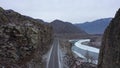 Road between rocks. Aerial view of asphalt road at Altai Republic. Modern silk path - Chuiskiy trakt