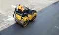 Road roller of an asphalt paving machine at work on freshly laid tarmac. Royalty Free Stock Photo