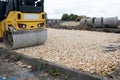 Road roller compacting stone during new road construction in preparation for tarmac Royalty Free Stock Photo