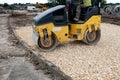 Road roller compacting stone during new road construction in preparation for tarmac Royalty Free Stock Photo