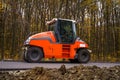 Road roller flattening new asphalt. Heavy vibration roller at work paving asphalt, road repairing. Selective focus. Royalty Free Stock Photo