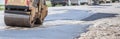 Road roller makes the paving.Close view on the road roller working on the road construction site Royalty Free Stock Photo