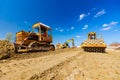 Road roller with spikes and earthmover are working at construction site Royalty Free Stock Photo