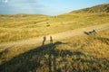 A road among sandy mountains, two shadows on the road, a moped on the road. Crimea. The road to Cape Meganom. Royalty Free Stock Photo