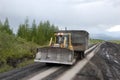 Road service tractor at gravel road Kolyma to Magadan highway Ya