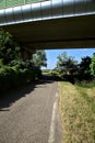 Road in the shade passing under a viaduct in the italian countryside in summer Royalty Free Stock Photo