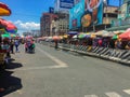 The road side of a national road of transport hub in Metro Manila crowded by people selling various items to form a flea market.