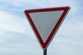 Road sign against the sky. White triangle with red border. Signal, Give way. Summer day Royalty Free Stock Photo