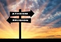 Road sign atheism and religion at sunset Royalty Free Stock Photo