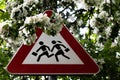 Road sign - Attention, children and white flowers