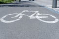 The road sign of the bike path. Drawing of bicycle with white paint on the asphalt.