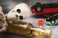 Road sign, a bottle of whiskey, a skeleton and an inverted car. Concept on the topic of drunk driving Royalty Free Stock Photo