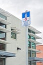 Road sign of EV charging station covered with icicles on overcast sky background Royalty Free Stock Photo