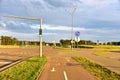 Road sign - the end of cycle path in city at pedestrian zone. Green traffic light signal on a motor road near an intersection and Royalty Free Stock Photo