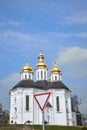 Road sign give way in front of the old church against the blue sky Royalty Free Stock Photo