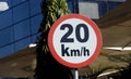 A road sign of 20 KMH twenty Kilometers per hour speed limit in the slow lane near gateway, restaurants and cafes, Prohibitory Royalty Free Stock Photo