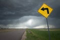 Road sign with Left Turn Arrow and Ominous Storm Background Royalty Free Stock Photo