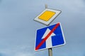 Road sign main road and one-way road end sign on blue sky background Royalty Free Stock Photo