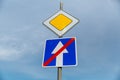 Road sign main road and one-way road end sign on blue sky background Royalty Free Stock Photo