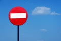 Road sign on a metal pole `Do not enter` sign against a blue sky with white clouds background. Royalty Free Stock Photo