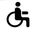 A road sign in the parking lot with the image of a person in a wheelchair. A place for the disabled