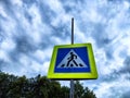 Road sign Pedestrian crossing. Blue square on a yellow background with a black figure of a walking person. Traffic rules Royalty Free Stock Photo