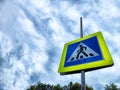 Road sign Pedestrian crossing. Blue square on a yellow background with a black figure of a walking person. Traffic rules Royalty Free Stock Photo