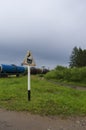 Road sign `Railway crossing without barrier` with oil tanks