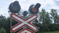 Road sign of railway crossing with double traffic light, shining red indicating approaching train Royalty Free Stock Photo