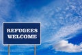 The road sign with Refugees welcome sign