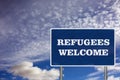 The road sign with Refugees welcome sign