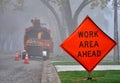 Road sign and service vehicle in foggy morning.