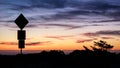 Road sign silhouette and colorful sunset Royalty Free Stock Photo