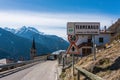 Road sign of small village Termenago, Trento, Italy. Buildings and snow-capped Italian mountains.