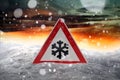 Traffic sign warns of snow and ice at road in winter Royalty Free Stock Photo