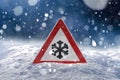 Traffic sign warns of snow and ice at road in winter Royalty Free Stock Photo