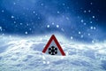 Traffic sign warns of snow and ice at road in winter Royalty Free Stock Photo