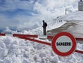 Road sign Stop. Warning of danger in the mountains. Avalanche retreat. Danger on the snow-capped mountain tops among the clouds. Royalty Free Stock Photo