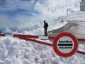 Road sign Stop. Warning of danger in the mountains. Avalanche retreat. Danger on the snow-capped mountain tops among the clouds. Royalty Free Stock Photo