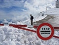 Road sign Stop. Warning of danger in the mountains. Avalanche retreat. Danger on the snow-capped mountain tops among the clouds. Royalty Free Stock Photo