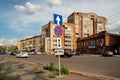 Road sign Stopping is prohibited stands on the Abalakov Brothers Street against the background of passing vehicles and city