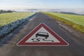 Road sign on a street with attention slippery when wet in spring, autumn, fall or winter Royalty Free Stock Photo