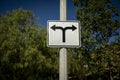 Road sign on a street pole with arrows pointed in opposite directions facing east and west