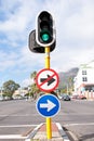 Road sign, traffic light and signage in street for direction with attention notification and arrow symbol outdoor in Royalty Free Stock Photo