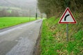 Road and road sign warning about a turn in the road. Road safety concept. A sign in red triangle indicating a right turn in the