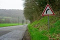 Road and road sign warning about a turn in the road. Road safety concept. A sign in red triangle indicating a right turn in the