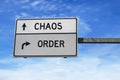 Road sign with words chaos and order. White two street signs with arrow on metal pole on blue sky background Royalty Free Stock Photo