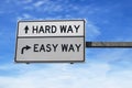 Road sign with words hard way and easy way. White two street signs with arrow on metal pole. Directional road, Crossroads Road Royalty Free Stock Photo